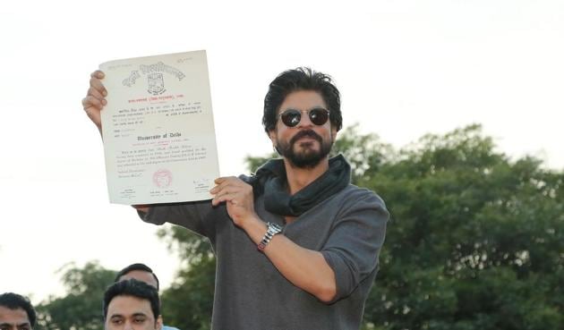 Bollywood actor Shah Rukh Khan poses with his degree on stage at Hansraj college.(Raajesh Kashyap/HT Photo)