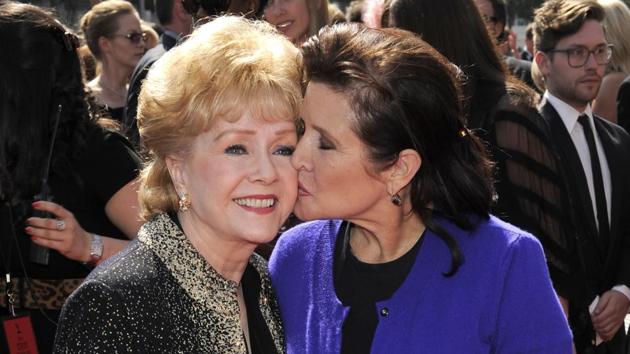In this September 10, 2011, file photo, Debbie Reynolds, left, and Carrie Fisher arrive at the Primetime Creative Arts Emmy Awards in Los Angeles. Reynolds, star of the 1952 classic "Singin' in the Rain" died Wednesday, December 28, 2016, according to her son Todd Fisher. (Chris Pizzello/AP File Photo) In this September 10, 2011, file photo, Debbie Reynolds, left, and Carrie Fisher arrive at the Primetime Creative Arts Emmy Awards in Los Angeles. Reynolds, star of the 1952 classic "Singin' in the Rain" died Wednesday, December 28, 2016, according to her son Todd Fisher. (Chris Pizzello/AP File Photo)