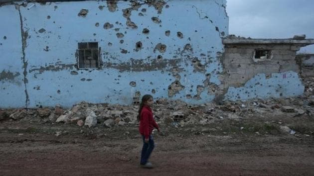 A girl walks past a damaged house in al-Rai town, northern Aleppo province in Syria.(Reuters photo) A girl walks past a damaged house in al-Rai town, northern Aleppo province in Syria.(Reuters photo)