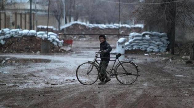 A boy walks his bike near stacked sandbags in al-Rai town, northern Aleppo province, Syria.(Reuters) A boy walks his bike near stacked sandbags in al-Rai town, northern Aleppo province, Syria.(Reuters)