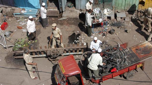 A file photo of local residents and police officers clearing debris at a blast site in Malegaon on September 30, 2008.(REUTERS) A file photo of local residents and police officers clearing debris at a blast site in Malegaon on September 30, 2008.(REUTERS)