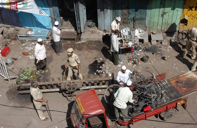 Locals and police officers clear debris at a blast site in Malegaon.(REUTERS)