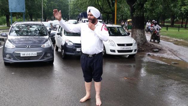 UT traffic head constable Harkewal Singh performed his duty barefooted in pouring rain.(HT Photo) UT traffic head constable Harkewal Singh performed his duty barefooted in pouring rain.(HT Photo)