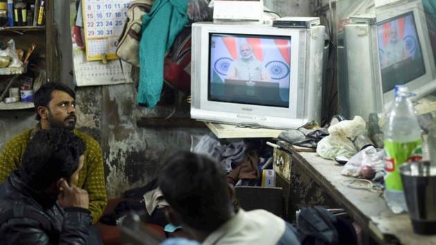 Workers watch Prime Minister Narendra Modi’s televised speech on New Year’s eve at their workshop in New Delhi.(Arun Sharma/HT Photo)