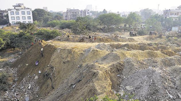A seasonal water body in DLF phase 3 was continuously filled with construction waste last year. Similar incidents were reported from different parts of the city and the first construction and demolition waste plant to be set up by the MCG is aimed at mitigating the issue.(HT File)