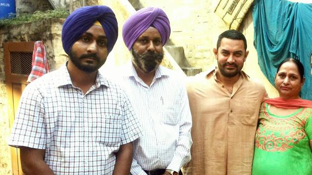 Omkarjot Singh with his parents and Aamir Khan during shoot of Dangal at his home in Kila Raipur in Ludhiana. (HT Photo) Omkarjot Singh with his parents and Aamir Khan during shoot of Dangal at his home in Kila Raipur in Ludhiana. (HT Photo)