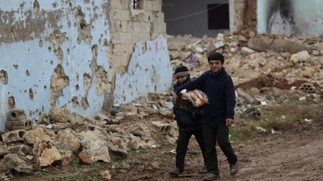 Boys carry bread near damaged buildings in al-Rai town, northern Aleppo countryside, Syria December 30, 2016. A ceasefire, brokered by Turkey and Russia, was announced on Dec 30, 2016.(REUTERS) Boys carry bread near damaged buildings in al-Rai town, northern Aleppo countryside, Syria December 30, 2016. A ceasefire, brokered by Turkey and Russia, was announced on Dec 30, 2016.(REUTERS)