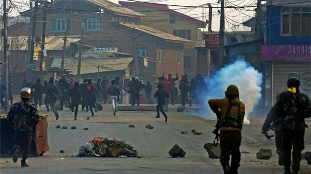 Police fire teargas shells as they chase away stone-pelting mob during a clash at Batmaloo in central Srinagar on Friday.(PTI)