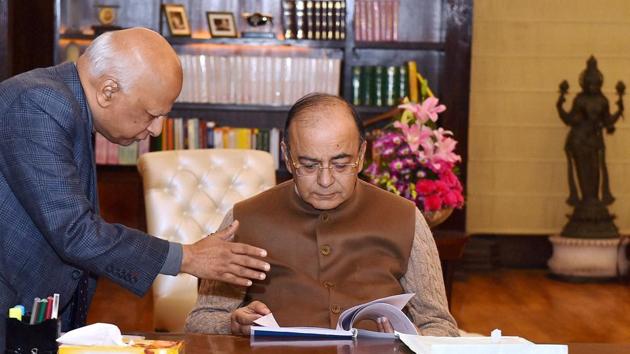 Union finance minister Arun Jaitley goes through a report presented to him, in New Delhi on Friday.(PTI)