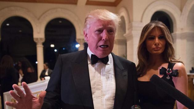 US President-elect Donald Trump answers questions from reporters accompanied by wife Melania for a New Year's Eve party at Mar-a-Lago in Palm Beach, Florida. / (AFP Photo) US President-elect Donald Trump answers questions from reporters accompanied by wife Melania for a New Year's Eve party at Mar-a-Lago in Palm Beach, Florida. / (AFP Photo)