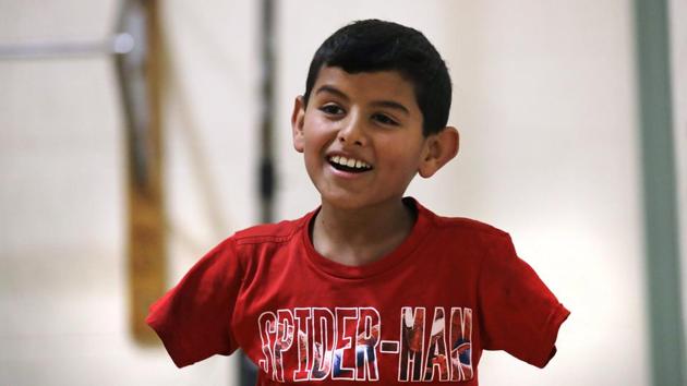 In this Dec.ember 10, 2016 photo, Syrian refugee Ahmad Alkhalaf smiles while playing with friends during a day camp for local Muslim children in Sharon, Mass. "Anything is possible in this world. You just have to believe in yourself," says Ahmad, whose arms were blown off above the elbows in a refugee camp bomb blast in 2014, which also killed three of his brothers. (AP Photo) In this Dec.ember 10, 2016 photo, Syrian refugee Ahmad Alkhalaf smiles while playing with friends during a day camp for local Muslim children in Sharon, Mass. "Anything is possible in this world. You just have to believe in yourself," says Ahmad, whose arms were blown off above the elbows in a refugee camp bomb blast in 2014, which also killed three of his brothers. (AP Photo)