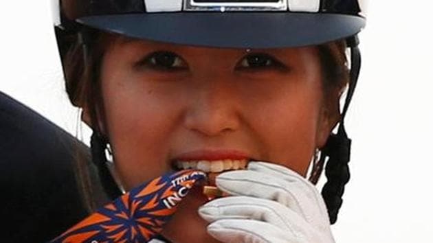 South Korea's Chung Yoo-ra, then known as Chung Yoo-yeon, bites her gold medal as she poses after winning the equestrian Dressage Team competition at the Dream Park Equestrian Venue during the 17th Asian Games in Incheon in 2014. (Reuters file photo) South Korea's Chung Yoo-ra, then known as Chung Yoo-yeon, bites her gold medal as she poses after winning the equestrian Dressage Team competition at the Dream Park Equestrian Venue during the 17th Asian Games in Incheon in 2014. (Reuters file photo)