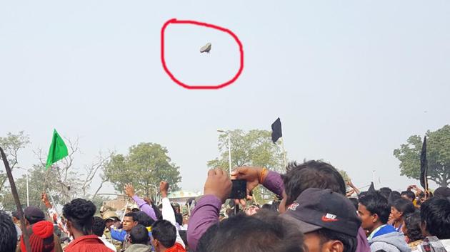 Locals wave black flags and hurl shoes (one encircled in red) at chief minister Raghubar Das inside Shahid Park in Kharsawan on Sunday. (HT Photo) Locals wave black flags and hurl shoes (one encircled in red) at chief minister Raghubar Das inside Shahid Park in Kharsawan on Sunday. (HT Photo)