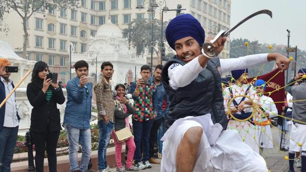 A student of one of the schools under the Chief Khalsa Diwan performs gatka, a traditional Sikh martial art, in a nagar kirtan during the 350th birth anniversary celebrations of Guru Gobind Singh, in Amritsar on Tuesday. (Sameer Sehgal/HT)
