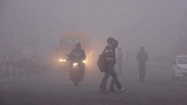 Bhopal: People and vehicles move through a thick blanket of fog in Bhopal. (PTI)