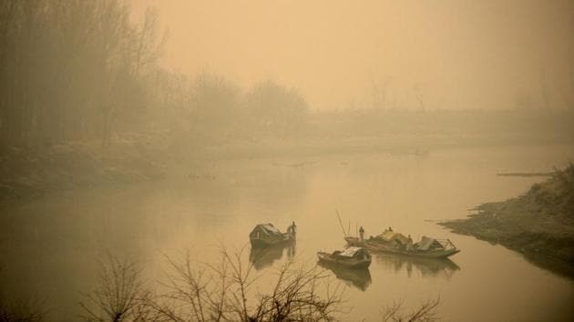 Kashmiri boatmen extract sand from river Jhelum on a foggy morning on the outskirts of Srinagar . A cold wave further tightened its grip in Jammu and Kashmir with most places in the state recording sub-zero temperatures. (AFP)