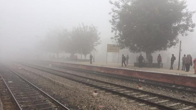 Dense fog covers Gurgaon railway station as commuters wait for their train. (Parveen Kumar/Ht Photo)