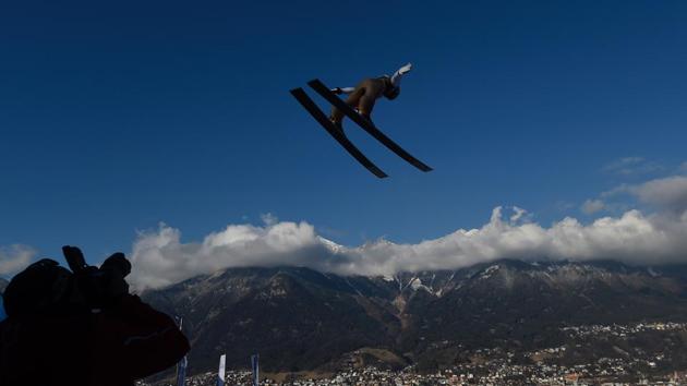 A photographer captures an unidentified athlete soaring through the air at the Ski jumping event. (Michal CIZEK / AFP)