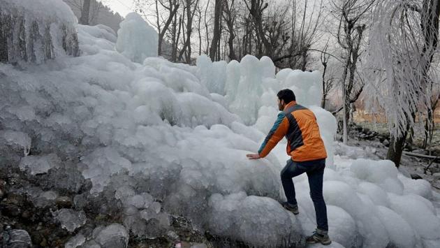 A man tries to climb huge icicles at Kokarnag in Kashmir’s Anantnag area. (PTI)