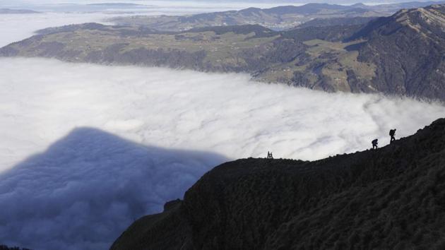 Two hikers walk on the Rigi mountain above a sea of fog, near Rigi Kulm, in the canton of Schwyz, central Switzerland. (Gaetan Bally/AP)