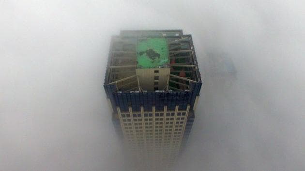 A building appears through a thick layer of fog in Yangzhou, in China's eastern Jiangsu province. Thick fog reduced visibility in the city, sometimes down to 50 metres. (AFP)