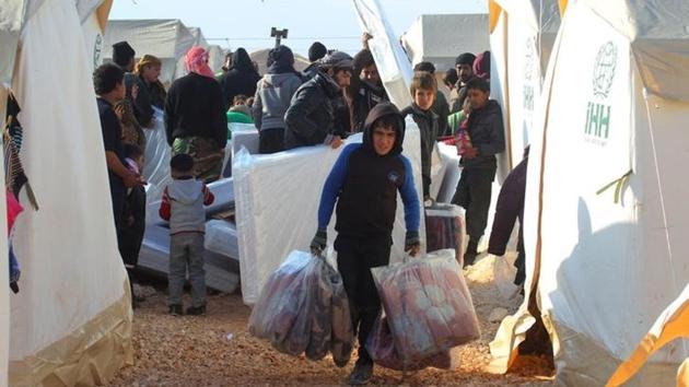 A boy, evacuee from a rebel-held area of Aleppo, carries blankets he received as aid in al-Kamouneh camp, Idlib province. (Reuters Photo) A boy, evacuee from a rebel-held area of Aleppo, carries blankets he received as aid in al-Kamouneh camp, Idlib province. (Reuters Photo)