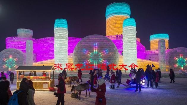 People visit ice sculptures illuminated by coloured lights at the Harbin Ice and Snow Festival to celebrate the new year in Harbin on January 4, 2017. (NICOLAS ASFOURI / AFP)