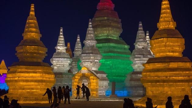 People visit ice sculptures illuminated by coloured lights at the Harbin Ice and Snow Festival to celebrate the new year in Harbin on January 4, 2017. (NICOLAS ASFOURI / AFP)