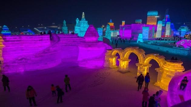 People visit ice sculptures illuminated by coloured lights at the Harbin Ice and Snow Festival to celebrate the new year in Harbin on January 4, 2017. (NICOLAS ASFOURI / AFP)