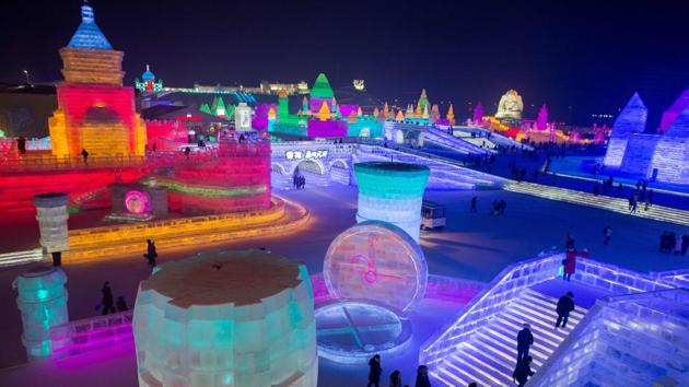People visit ice sculptures illuminated by coloured lights at the Harbin Ice and Snow Festival to celebrate the new year in Harbin on January 4, 2017. (NICOLAS ASFOURI / AFP)