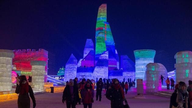 People visit ice sculptures illuminated by coloured lights at the Harbin Ice and Snow Festival to celebrate the new year in Harbin on January 4, 2017. (NICOLAS ASFOURI / AFP)