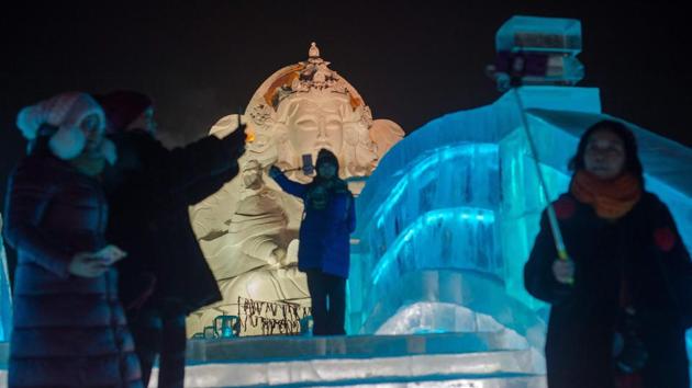 People visit ice sculptures illuminated by coloured lights at the Harbin Ice and Snow Festival to celebrate the new year in Harbin on January 4, 2017. (NICOLAS ASFOURI / AFP)