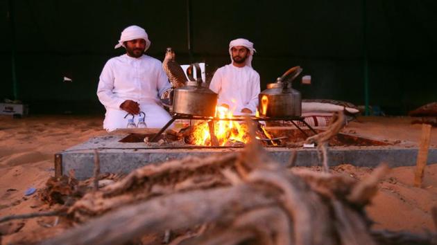 Emiratis from the Qubaisi tribe sit next to a fire after training falcons in the Liwa desert. (Karim Sahib/AFP) Emiratis from the Qubaisi tribe sit next to a fire after training falcons in the Liwa desert. (Karim Sahib/AFP)