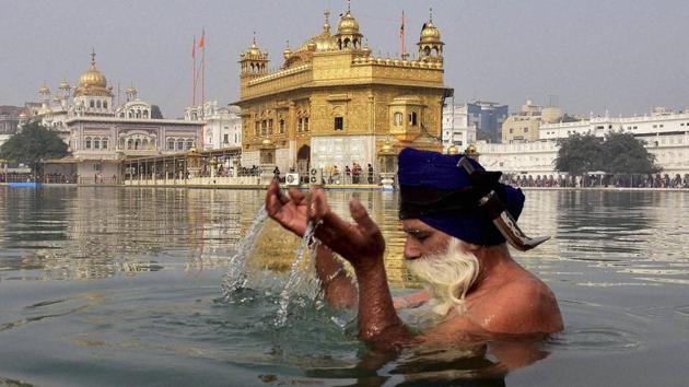 A Sikh devotee takes dip in the holy sarovar on the occasion in the Golden Temple premises in Amritsar on Thursday. (PTI) 