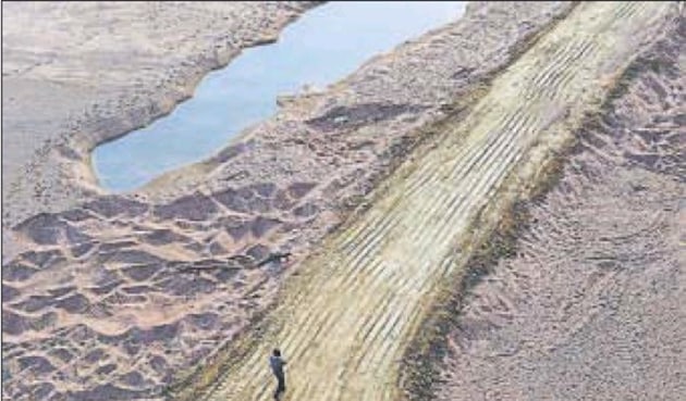 A man walks over truck tire tracks on Ken’s river bed. (Vipin Kumar/Hindustan Times) A man walks over truck tire tracks on Ken’s river bed. (Vipin Kumar/Hindustan Times)