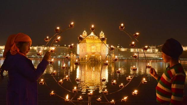 Devotees light candles at Golden Temple on the occasion of 350th birth anniversary of Guru Gobind Singh on Thursday. (Sameer Sehgal/HT Photo)