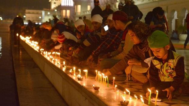 Devotees light candles at Golden Temple on the occasion of 350th birth anniversary of Guru Gobind Singh on Thursday. (Sameer Sehgal/HT Photo)