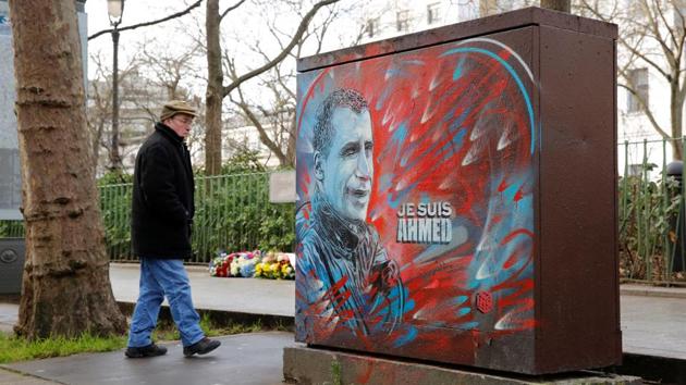 A man walks past a tribute to a slain police officer not far from the old offices of the satirical Charlie Hebdo magazine where two brothers armed with assault rifles shot and killed 11 people, including most of the publication's cartoonists and writers, on January 7, 2015, as France pays tribute two years later in Paris on Thursday. (Reuters) A man walks past a tribute to a slain police officer not far from the old offices of the satirical Charlie Hebdo magazine where two brothers armed with assault rifles shot and killed 11 people, including most of the publication's cartoonists and writers, on January 7, 2015, as France pays tribute two years later in Paris on Thursday. (Reuters)