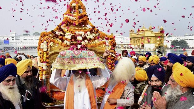 Sikh devotees take part in a procession at the Golden Temple on the eve of the 350th birth anniversary of Guru Gobind Singh in Amritsar on Wednesday. (PTI) 