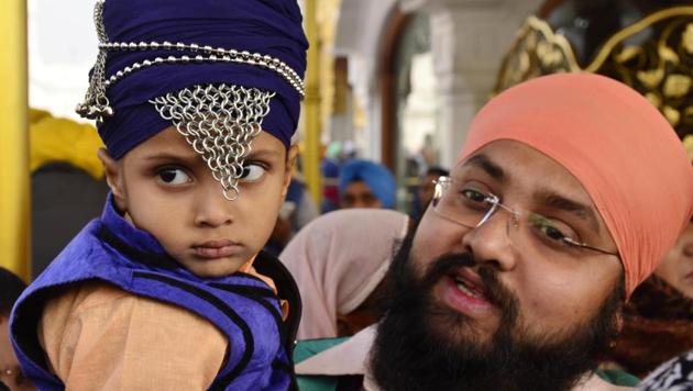 A Sikh boy with his family paying obeisance at Golden Temple on Thursday. (Sameer Sehgal/HT Photo)