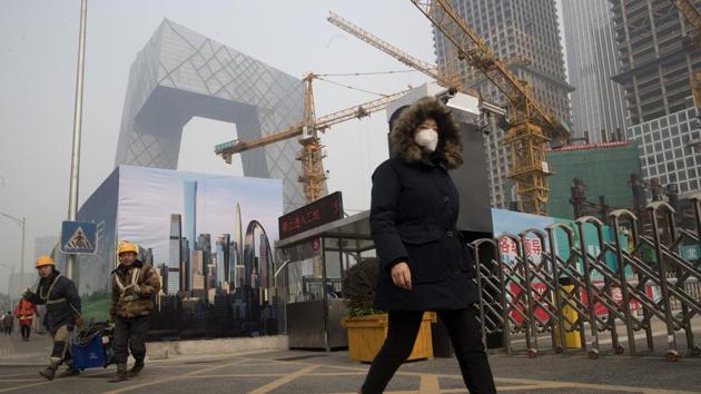 A woman wearing a mask walks past a construction site as smog continues to choke Beijing on Friday, Jan. 6, 2017.(AP Photo) A woman wearing a mask walks past a construction site as smog continues to choke Beijing on Friday, Jan. 6, 2017.(AP Photo)