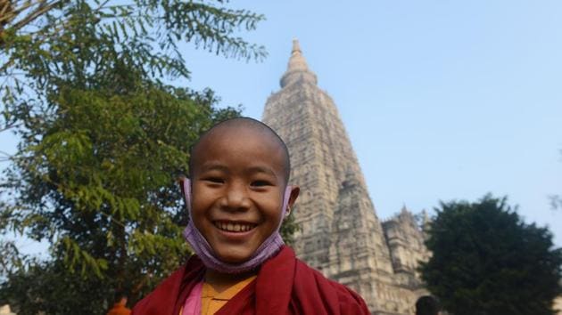 A young Buddhist monk smiles as he arrives to pray at the Mahabodhi temple where the Buddha is said to have attained enlightenment. (AFP PHOTO / Dibyangshu SARKAR) 
