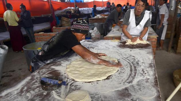 Buddhist volunteers prepare traditional bread to distribute among the devotees participating in the Kalachakra event. (AFP PHOTO / Dibyangshu SARKAR) 