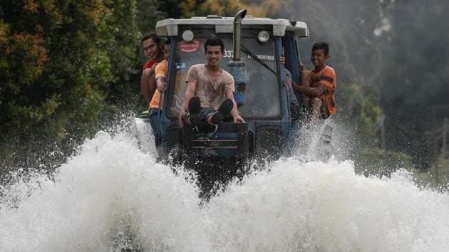 Local residents use a tractor to drive through floodwaters in Jal Besar, Malaysia's northeastern town of Tumpat on January 5, 2017. (MOHD RASFAN/ / AFP) Local residents use a tractor to drive through floodwaters in Jal Besar, Malaysia's northeastern town of Tumpat on January 5, 2017. (MOHD RASFAN/ / AFP)