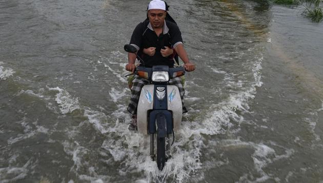 A local resident rides a motorcycle with his wife through floodwaters in Jal Besar, Malaysia's northeastern town of Tumpat, which borders Thailand on January 6, 2017. (MOHD RASFAN / AFP) A local resident rides a motorcycle with his wife through floodwaters in Jal Besar, Malaysia's northeastern town of Tumpat, which borders Thailand on January 6, 2017. (MOHD RASFAN / AFP)