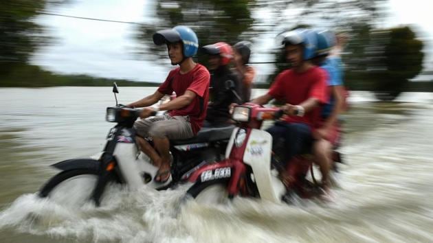 Motorcyclists ride through floodwaters in Jal Besar, Malaysia's northeastern town of Tumpat, on January 5, 2017. Floods continued to inundate two northeast Malaysian states on January 5, as thousands of people remained in relief centres while others expressed fears of looting and sought aid. (MOHD RASFAN / AFP) Motorcyclists ride through floodwaters in Jal Besar, Malaysia's northeastern town of Tumpat, on January 5, 2017. Floods continued to inundate two northeast Malaysian states on January 5, as thousands of people remained in relief centres while others expressed fears of looting and sought aid. (MOHD RASFAN / AFP)
