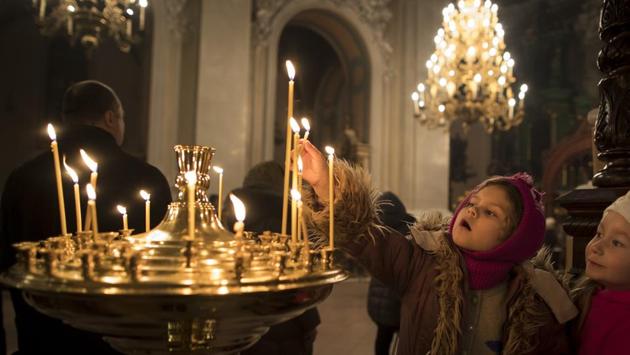 A child lights a candle, during the liturgy on Orthodox Christmas Eve in the Prechistensky, the Cathedral Palace in Vilnius, Lithuania. (Mindaugas Kulbis/AP)