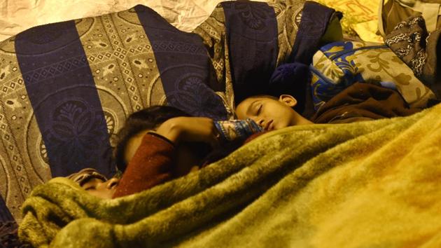 Families huddled together in the cold outside AIIMS. (Saumya Khandelwal/HT PHOTO) 