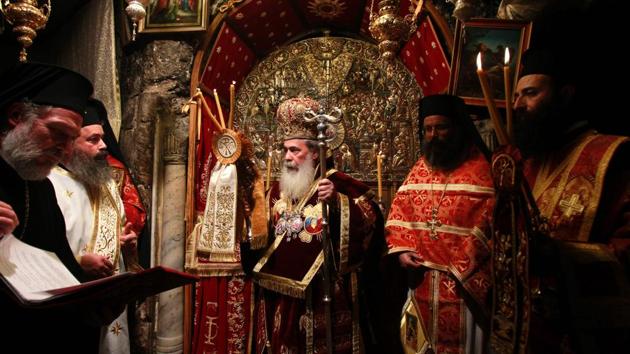 Greek Orthodox Patriarch of Jerusalem Theophilos III (C) leads the midnight mass at the Church of the Nativity in the biblical West Bank town of Bethlehem. (MUSA AL SHAER/AFP)