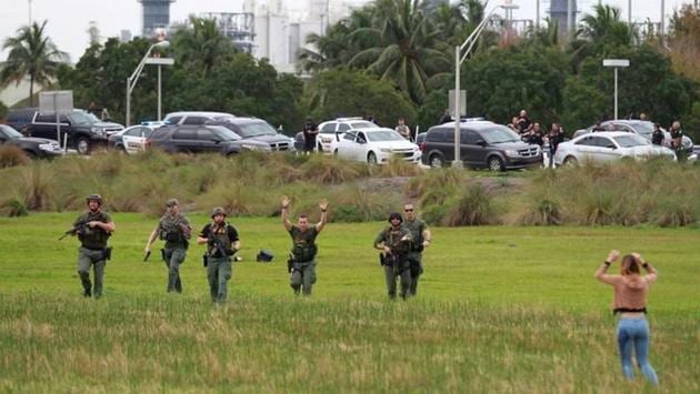 Law enforcement officers move in to verify the identity of people in this field just outside the airport perimeter following a shooting incident at Fort Lauderdale-Hollywood International Airport in Fort Lauderdale. (Reuters) Law enforcement officers move in to verify the identity of people in this field just outside the airport perimeter following a shooting incident at Fort Lauderdale-Hollywood International Airport in Fort Lauderdale. (Reuters)